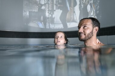 Family World Multimedia Erlebnisdom Vater und Tocher beim Filmschauen | © Alpentherme Gastein/Marktl Photography