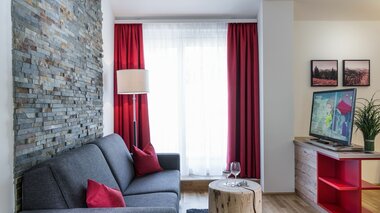 Fuchs Apartments Wohnbereich mit Couch und TV | © Fuchs Apartments